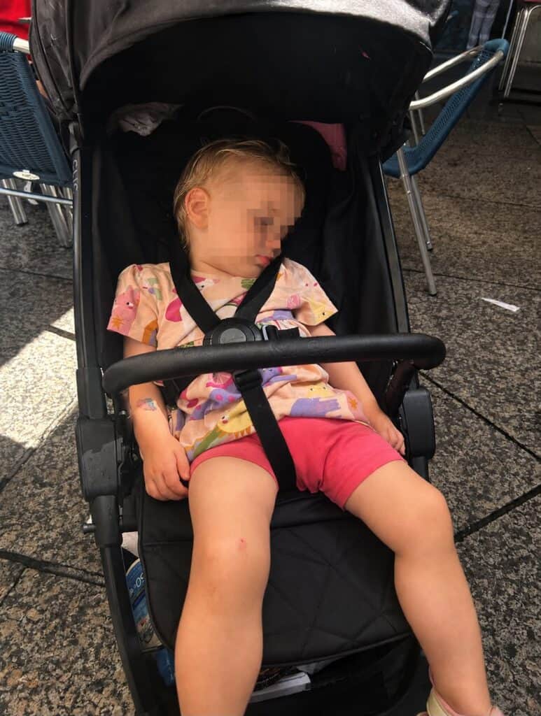 Toddler sleeping in a buggy during a family trip to San Sebastián