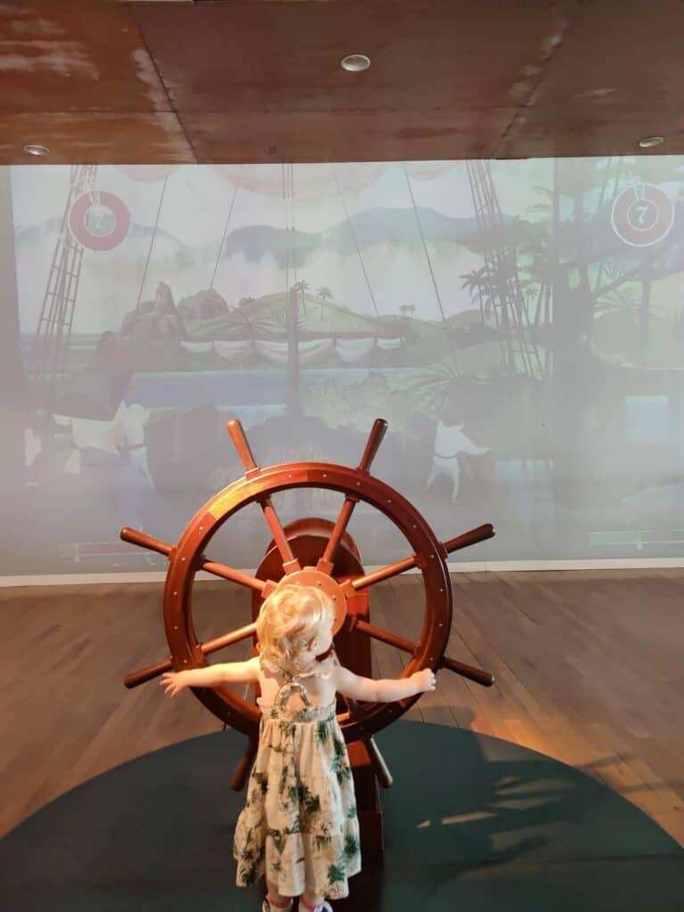 Our toddler at the ship's wheel in Pabellón de la Navegación, Seville